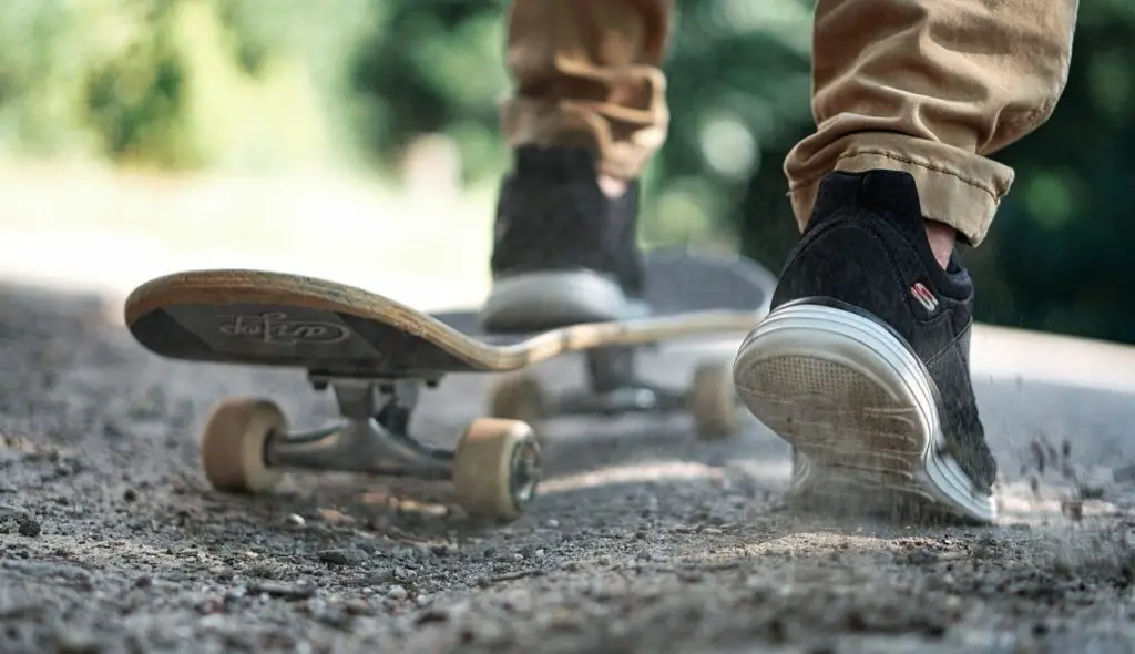 boy on dirt road with skateboard